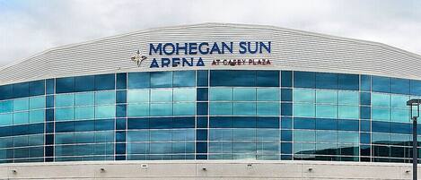 Mohegan Sun Arenas exteriör, belägen vid Casey Plaza, med en modern glasfasad och ett böjt tak.