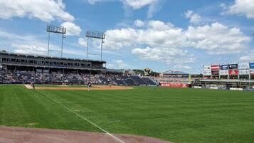 A baseball stadium with a large seating area, a well-maintained field, and multiple advertising billboards.