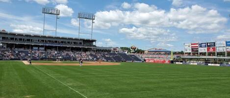 A baseball stadium with a large seating area, a well-maintained field, and multiple advertising billboards.