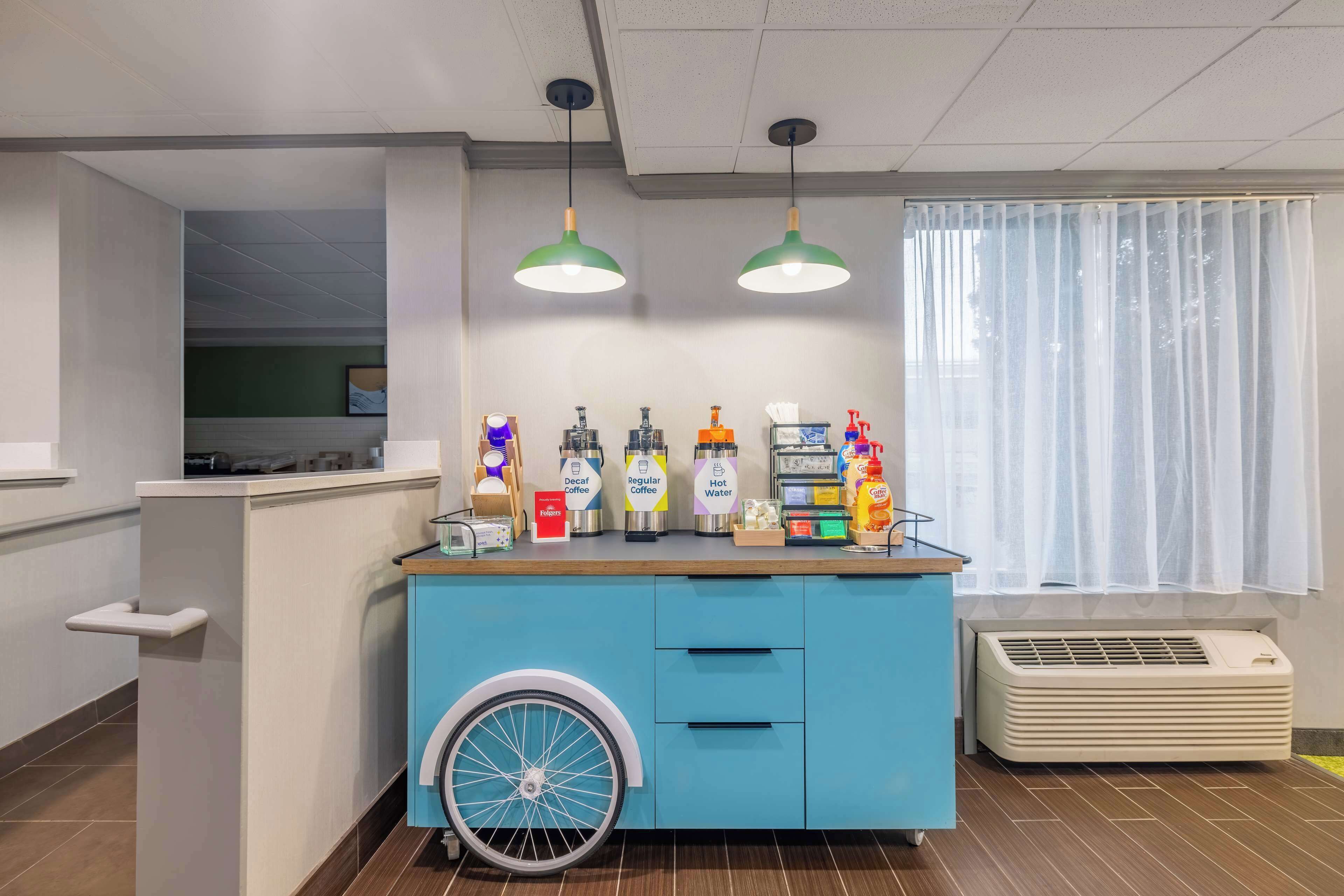 A counter with various beverage dispensers and a wheelchair-accessible design.