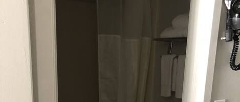 A bathroom with a toilet, a shower curtain, and a towel rack.