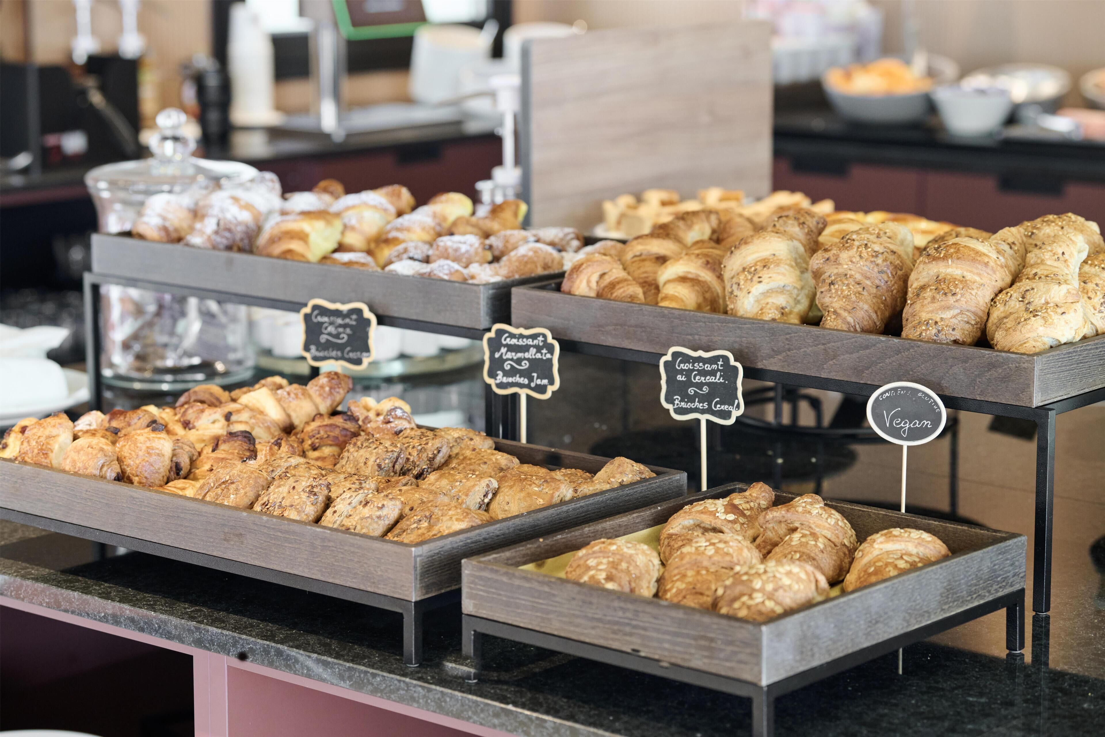 Een bakkerijvitrine met diverse gebakjes.