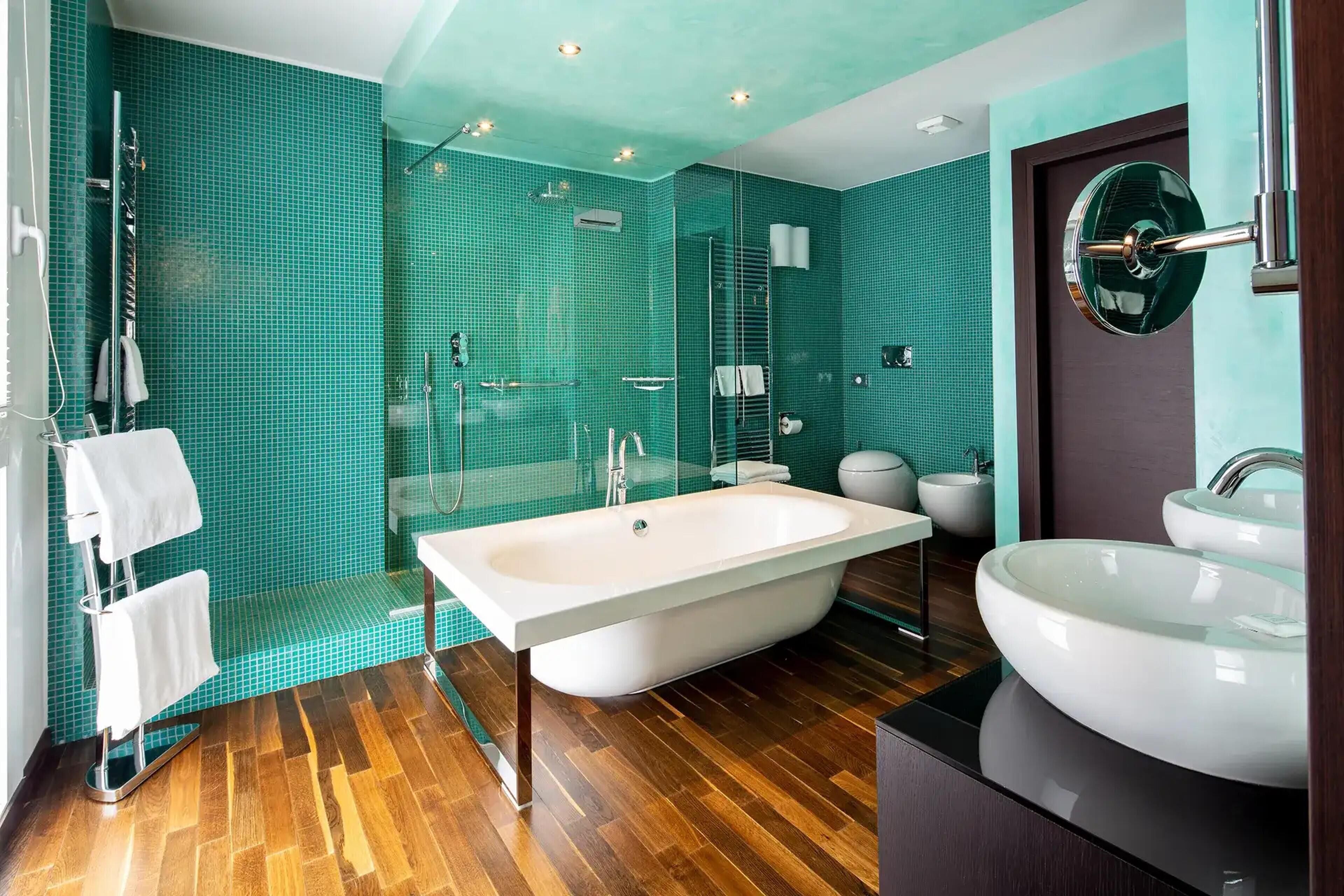 A modern bathroom with a freestanding bathtub, a large sink, and a glass-enclosed shower area.