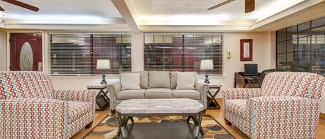A living room with a sofa set, a coffee table, and a ceiling fan.