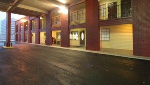 A multi-story building with a garage entrance, large windows, and a visible garage door. - Howdy Hotel (College Station)