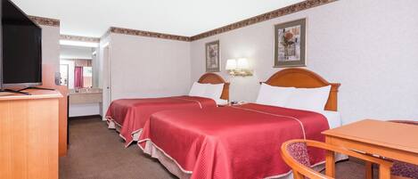 Habitación de hotel con dos camas, un escritorio, una silla y un televisor.