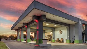 A gas station with a clear canopy, a star decoration on the wall, and a sign indicating a 12-foot clearance.