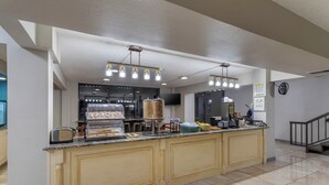 A hotel kitchen with a central island, a microwave, and a coffee machine.
