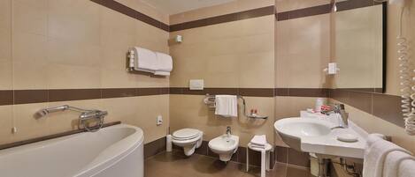 Un baño moderno con bañera, inodoro, bidé y lavabo.