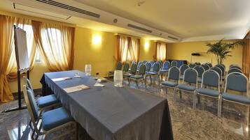 Une salle de conférence équipée d’une longue table, de chaises et d’un écran de projection.