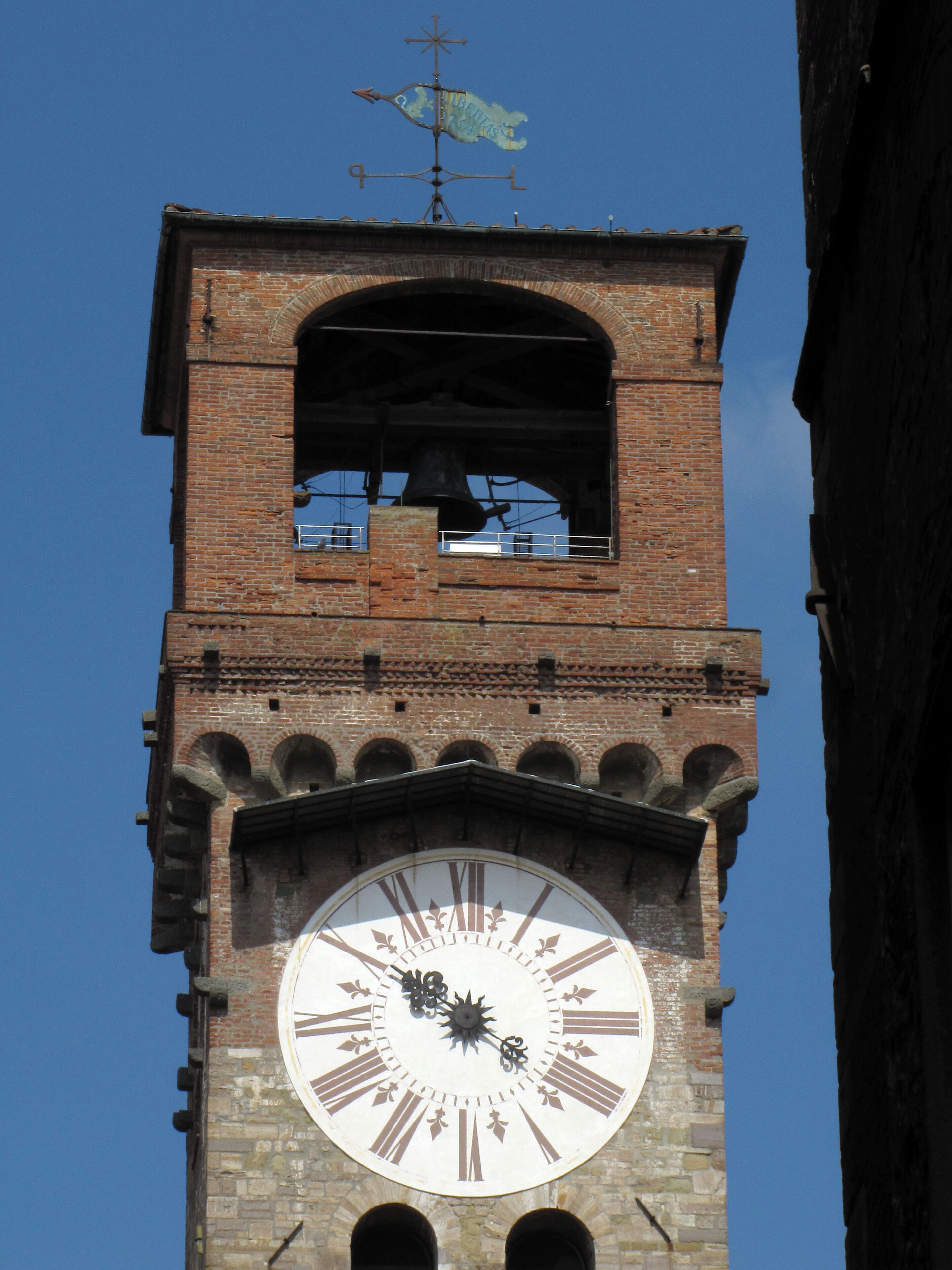 A clock tower with a large clock face and a bell.