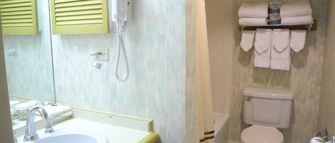 A bathroom with a sink, toilet, and a towel rack.
