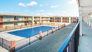 A motel with a swimming pool, multiple balconies, and a clear sky. - OYO Hotel Oklahoma City South I-35 and SE 29th (Oklahoma City)