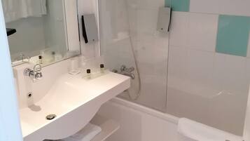 A modern bathroom with a white sink, mirror, and shower.