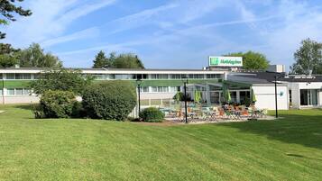Un hôtel Holiday Inn doté d’une piscine, d’un espace extérieur aménagé avec des sièges et d’une pelouse bien entretenue.