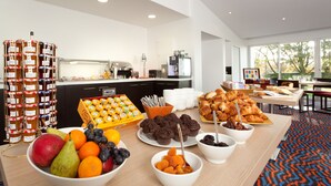 Buffet de l'esmorzar amb diverses fruites, pastissos i condiments.