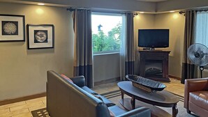 A living room with a sofa, a table, a television, and a fireplace.