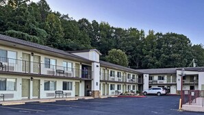 A motel with multiple floors, outdoor seating, and a parking lot.