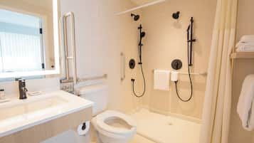A modern bathroom with a toilet, sink, and shower.
