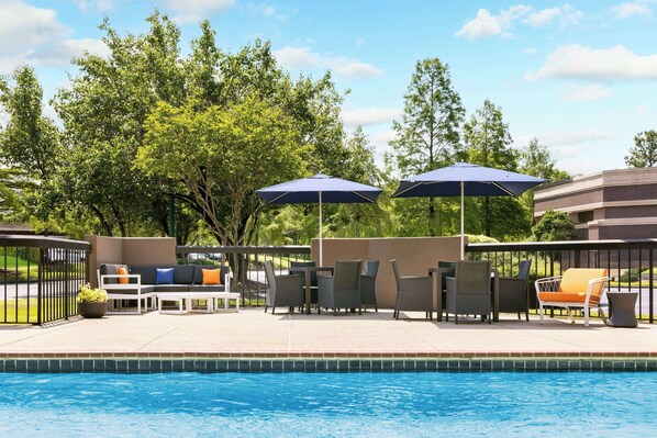 Una piscina al aire libre, sombrillas