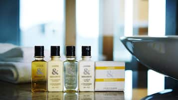Four bottles of JASMIN Bergamot body wash and a box of JASMIN Bergamot soap on a reflective surface.