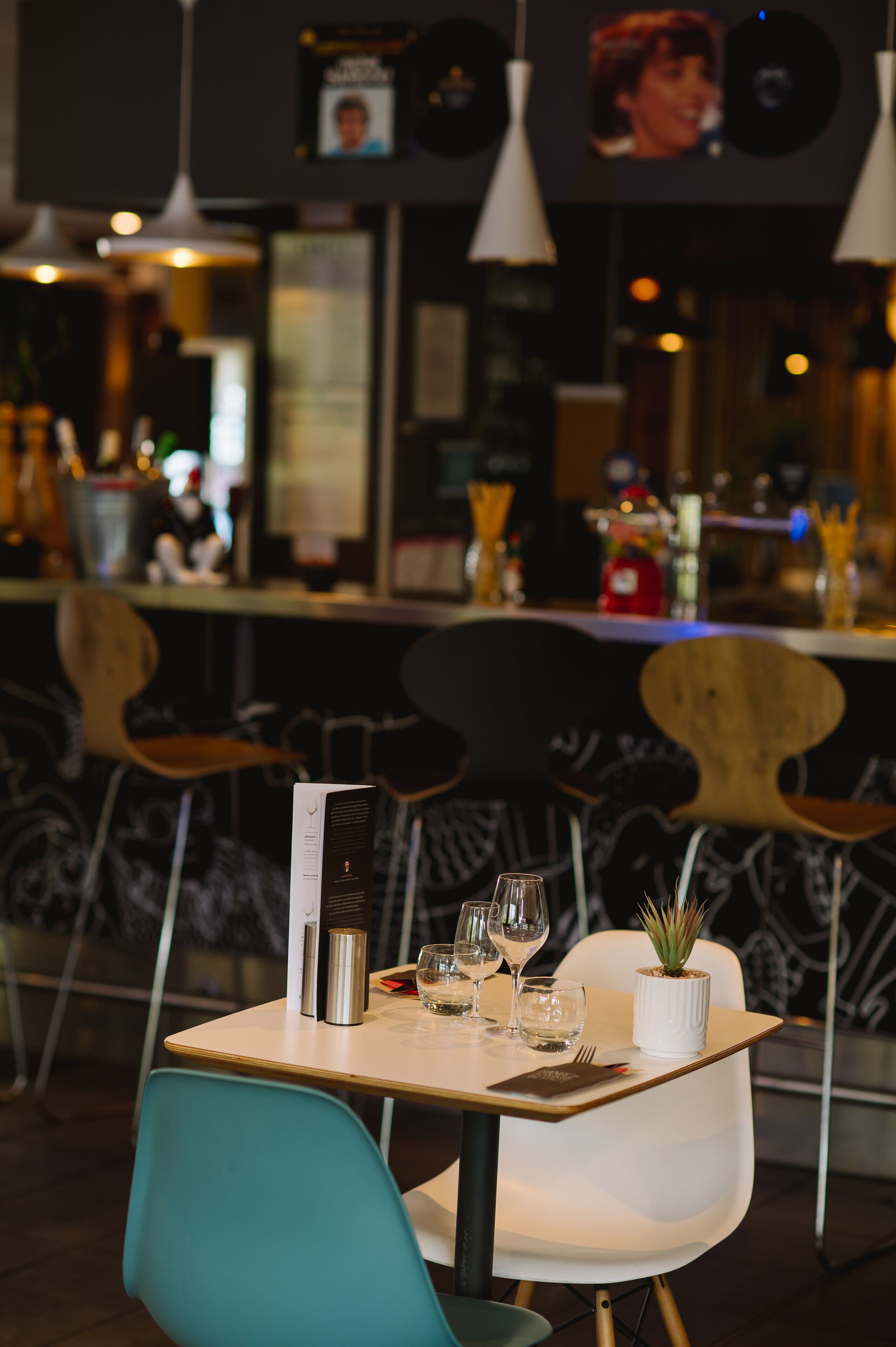 Interior de restaurante con una mesa para dos, un menú y copas de vino.