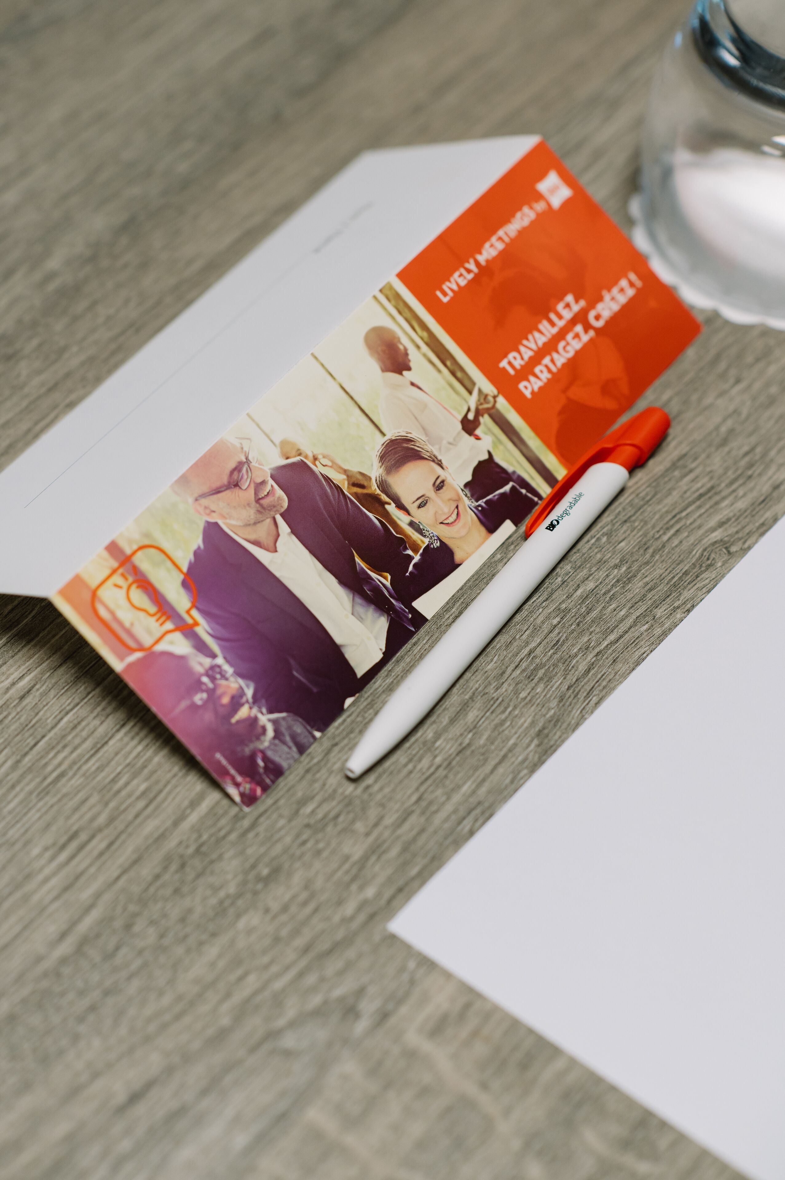 A brochure with a pen on a wooden surface.