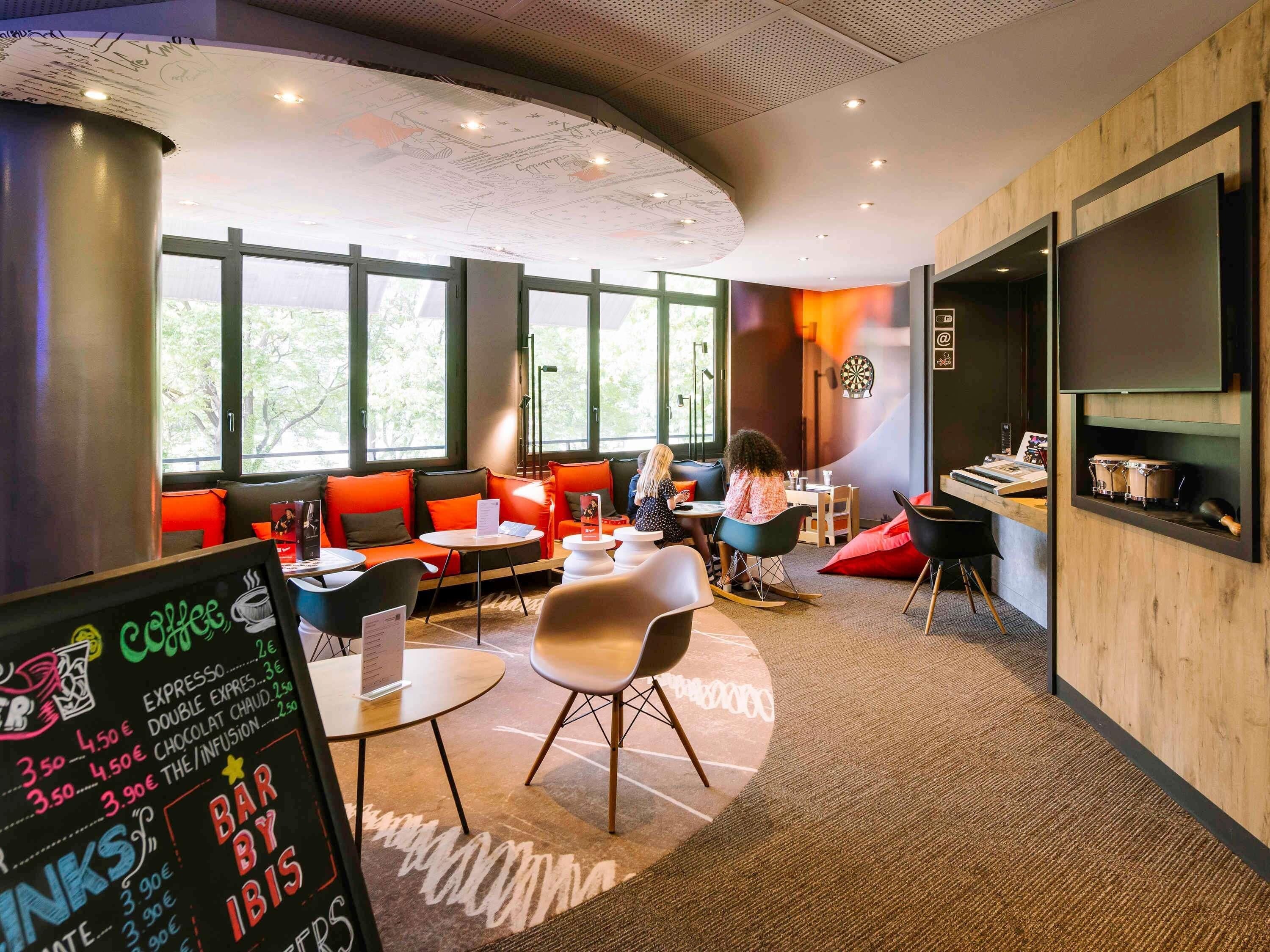 Un café moderne doté d’espaces pour s’asseoir, d’un menu écrit à la craie et de grandes fenêtres.