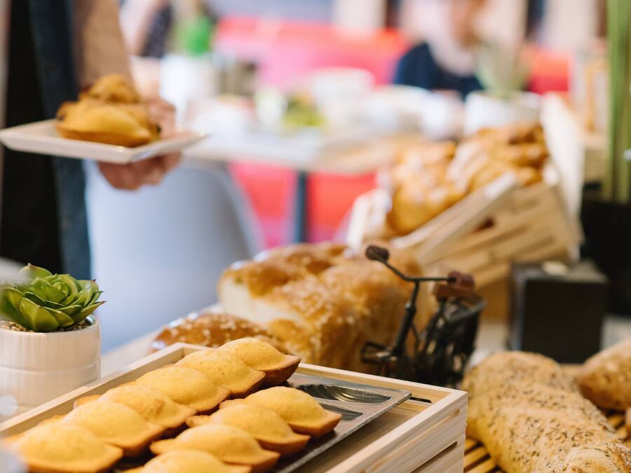 A buffet with various food items including pastries, bread, and crackers.