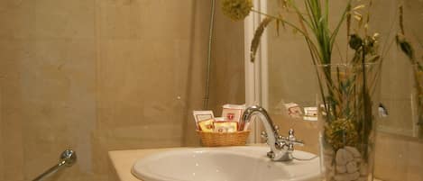 Un baño con lavamanos, espejo y ducha.