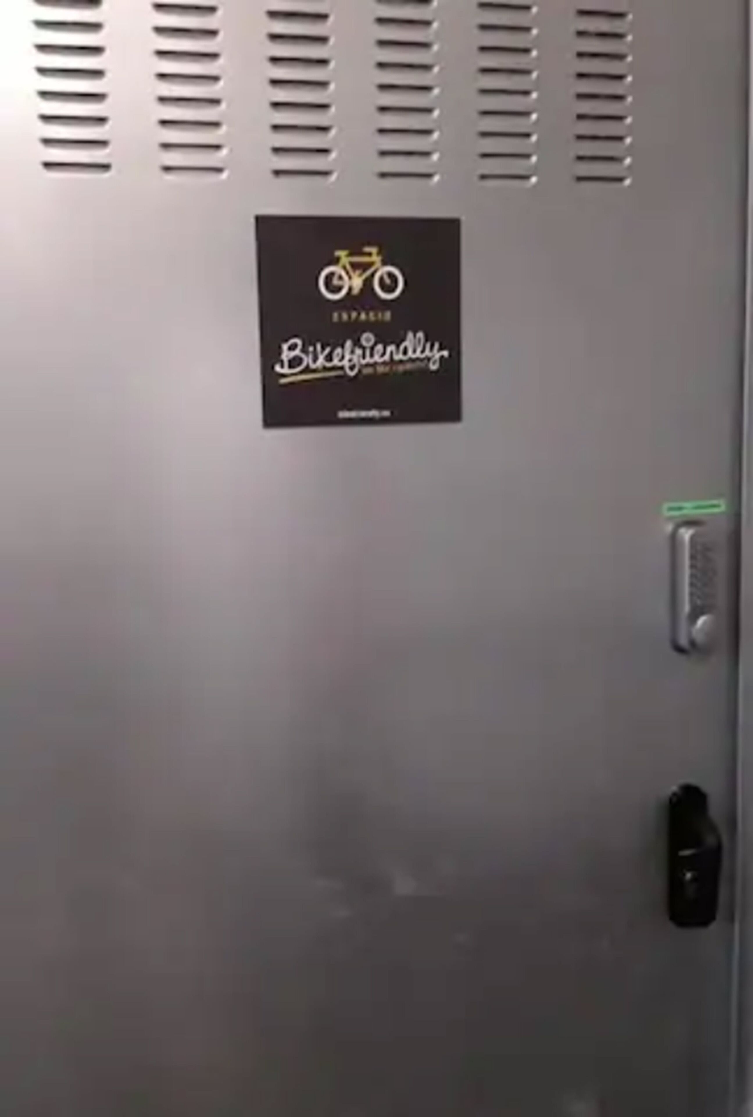 Een metalen locker met een bordje 'Bikefriendly', een keypad en een slot.