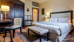 A hotel room with a large bed, a desk, a chair, and a bench. - Hotel Temple Ponferrada (Ponferrada)