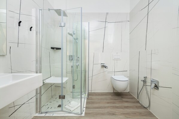 A modern bathroom with a glass-enclosed shower, a white toilet, and a wooden floor. - Hotel Maggiore Bologna (Bologna)