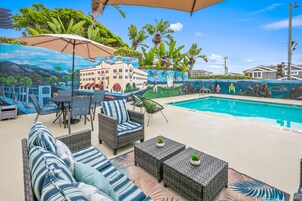 Una piscina al aire libre, sombrillas, sillones reclinables de piscina
