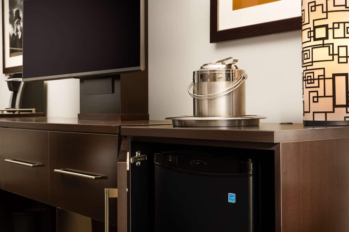 A compact kitchenette with a built-in refrigerator, a microwave, and a small stove.