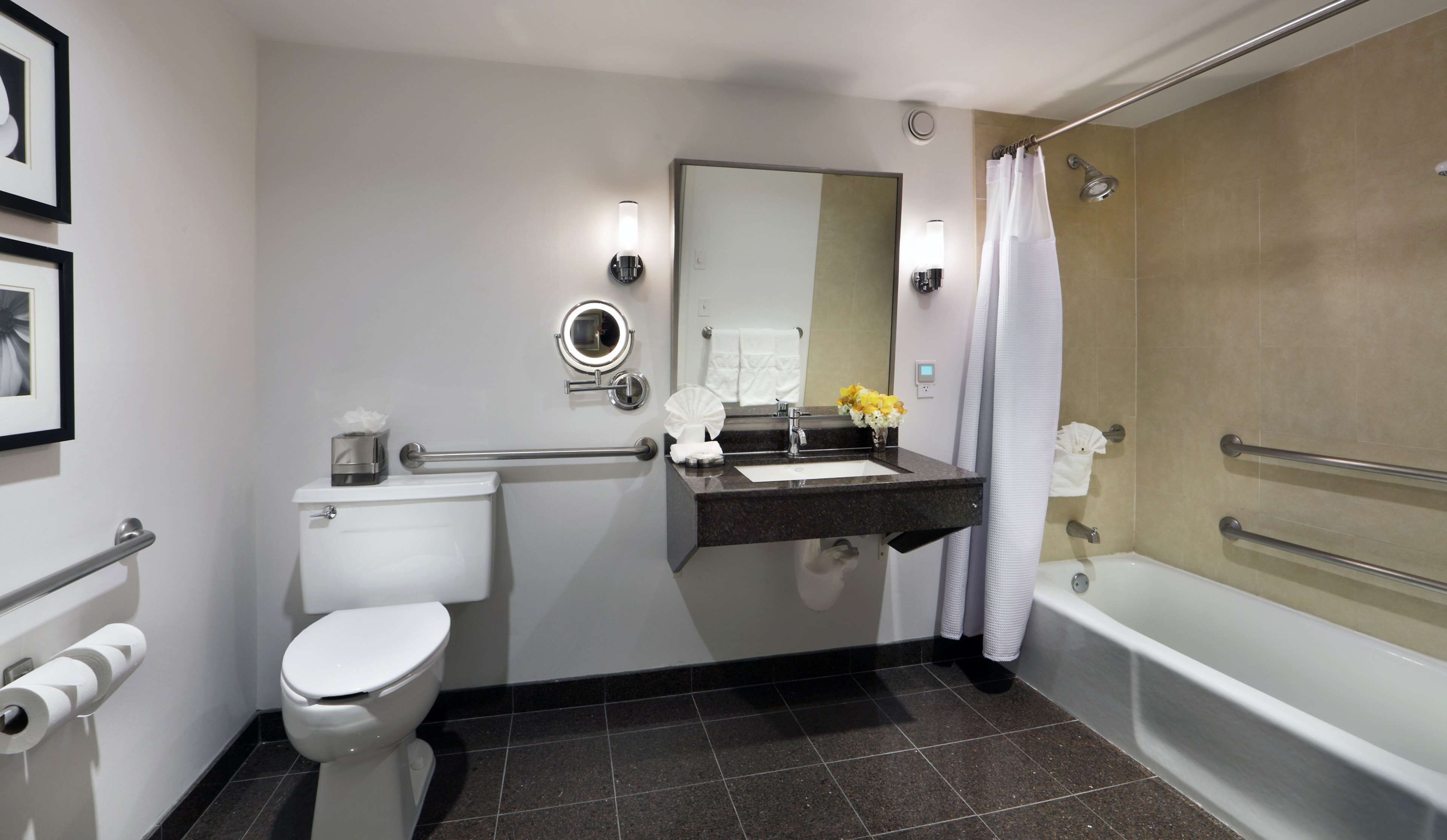 Ein modernes Badezimmer mit Toilette, Waschbecken, Spiegel und Badewanne.