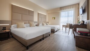 A hotel room with two beds, a desk, a chair, a TV, and a window with curtains. - JR Hotels Bologna Gate 7 (Calderara di Reno)