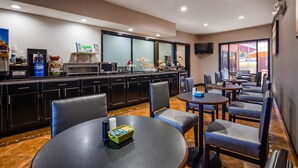 A hotel room with a kitchenette, a TV, and a seating area with tables and chairs. - Best Western Jacksonville near Little Rock Air Force Base (Jacksonville)