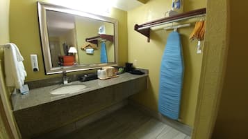 A bathroom with a sink, mirror, towel rack, and shower curtain.