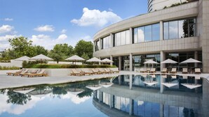 Ein modernes Gebäude mit Pool, Liegestühlen und Sonnenschirmen.
