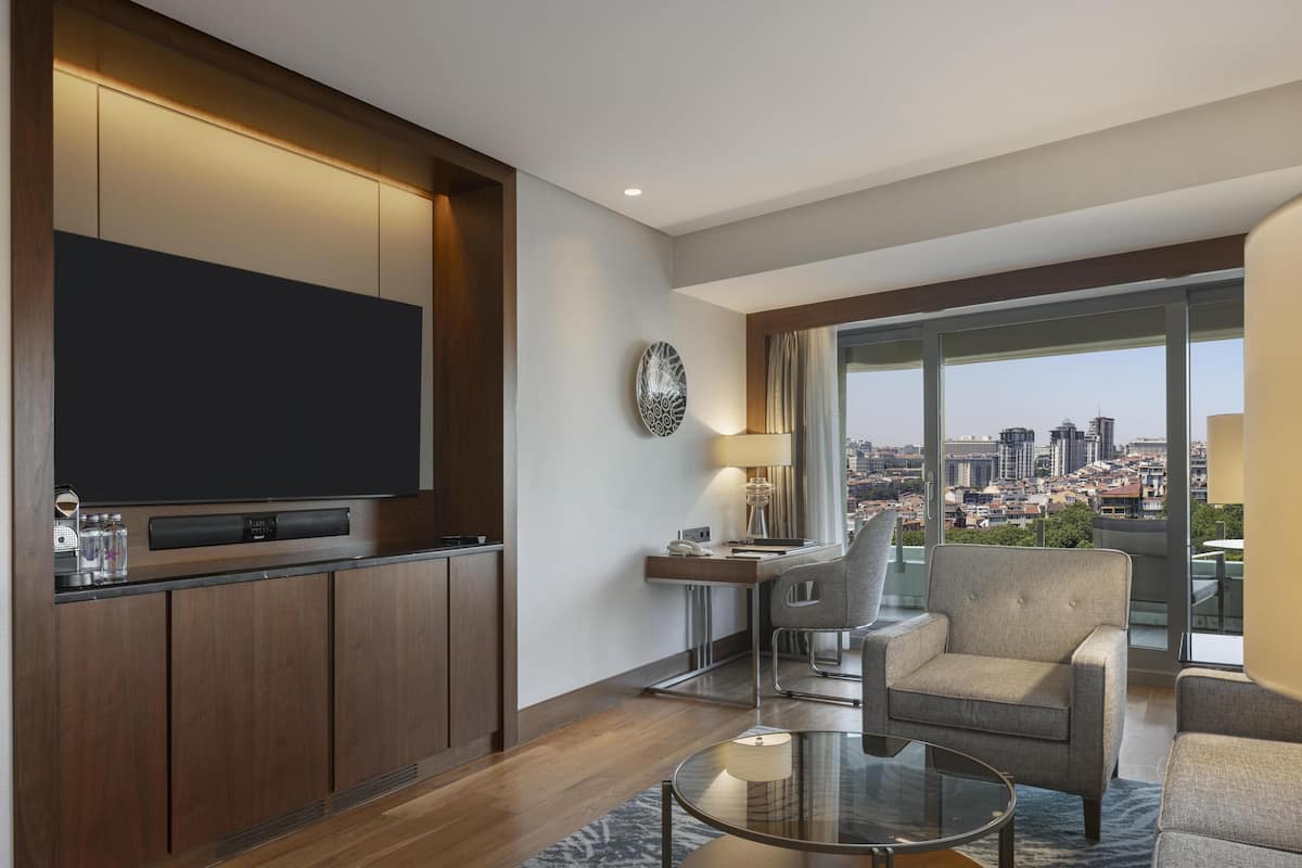 Suite, 1 cama King size, balcón | Área de sala de estar | Televisión LED de 46 pulgadas con canales vía satélite y televisión