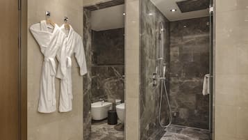 Un baño moderno con ducha a nivel, bañera y retrete.