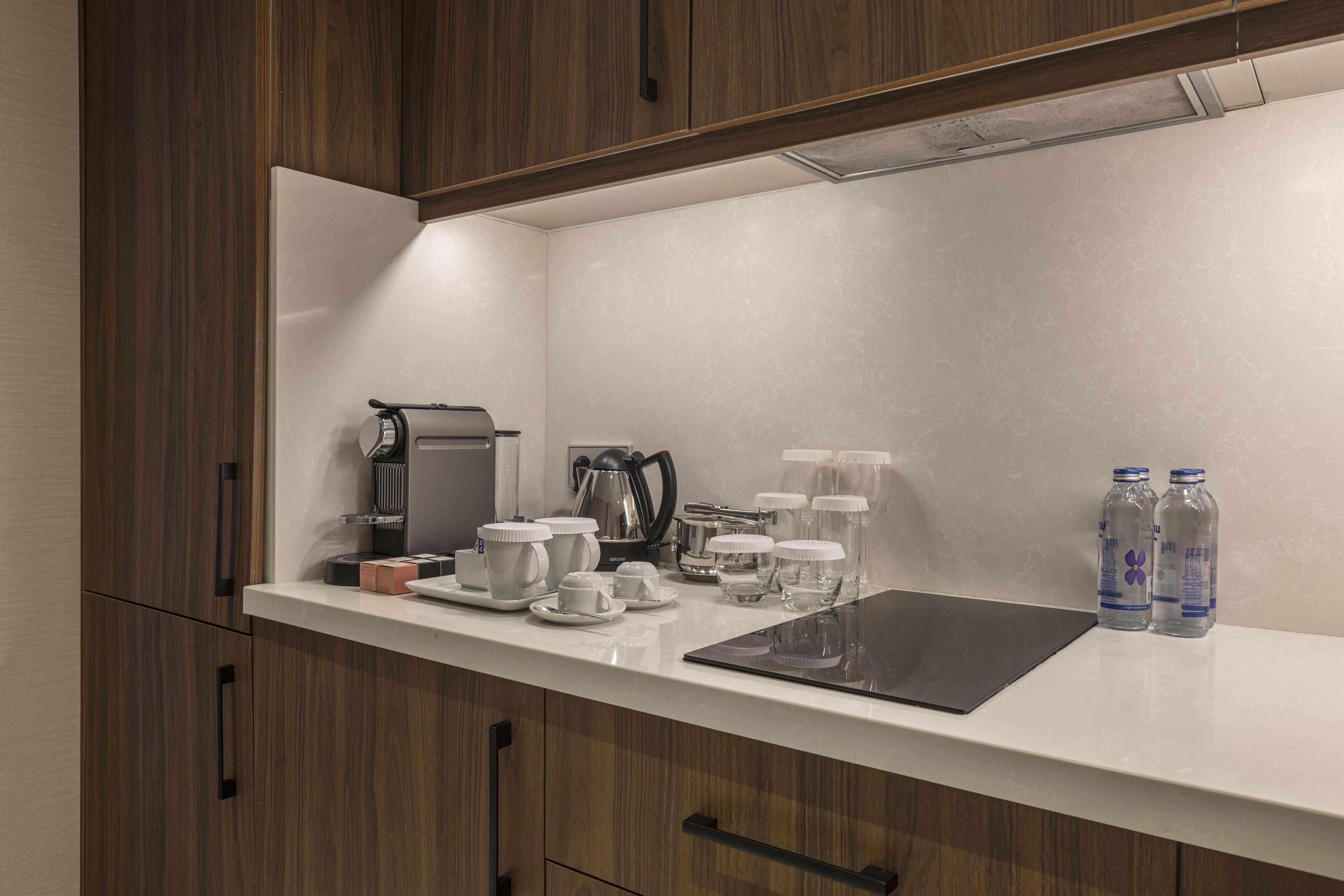 Una cocina moderna con armarios de madera, una encimera blanca y diversos electrodomésticos.