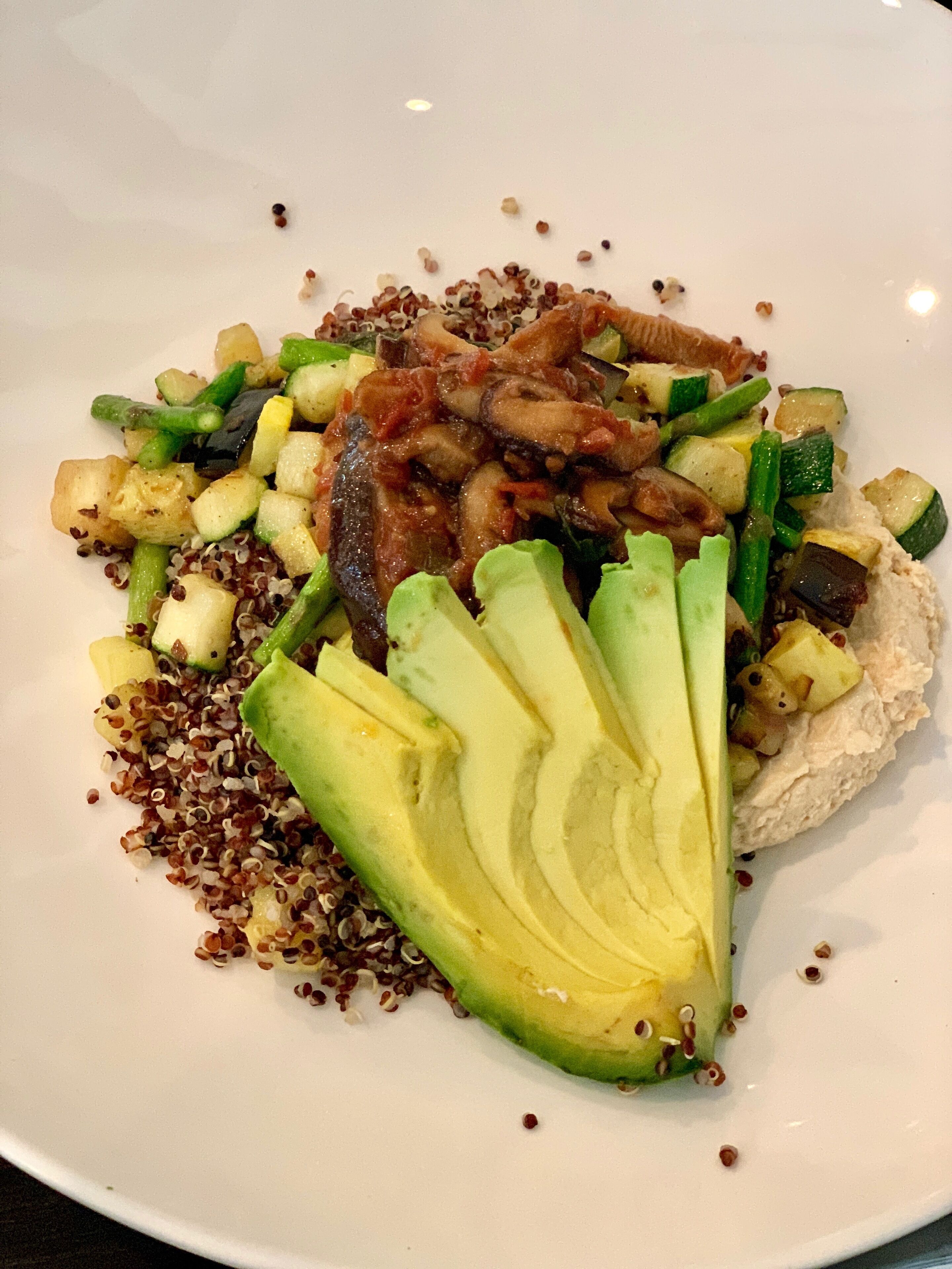A plate of food with various vegetables and quinoa.