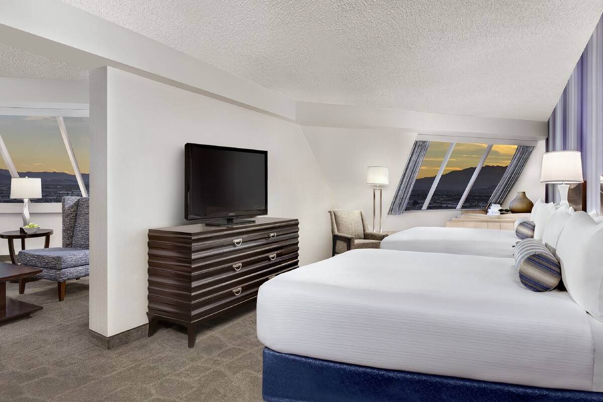 Une chambre d’hôtel avec un lit, une télévision, un bureau et une chaise.
