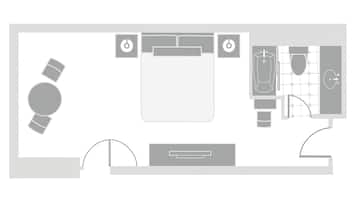 A hotel room layout with a bed, bedside tables, a desk, and a bathroom.