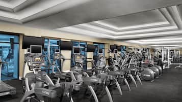 Una palestra con tapis roulant, cyclette e macchinari per l'allenamento della forza.