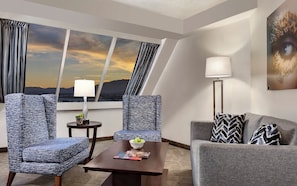 A hotel room with two armchairs, a sofa, a coffee table, a lamp, and a painting. - Luxor Hotel and Casino (Las Vegas)