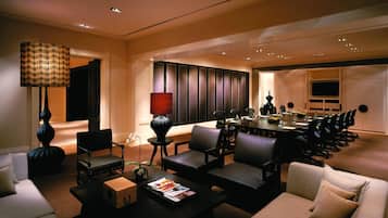 A conference room with a long table, multiple chairs, and a television.