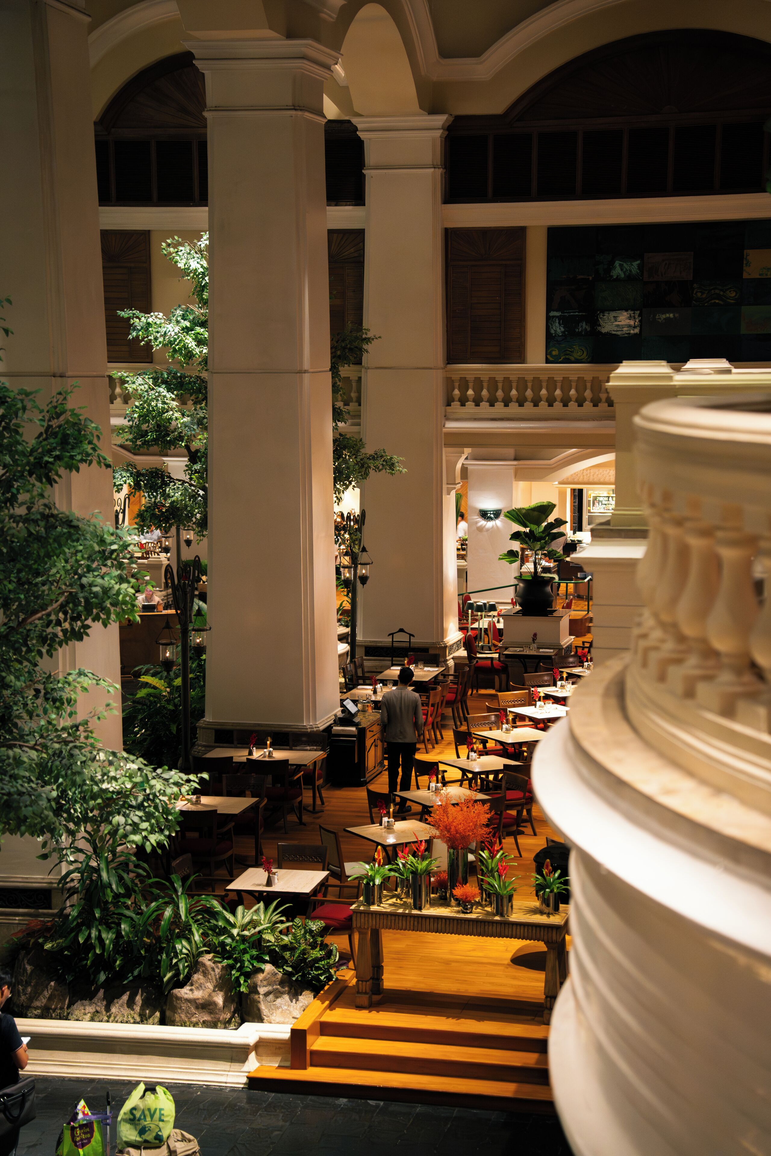Un atrium intérieur doté de hauts plafonds, de colonnes et d’un escalier central.
